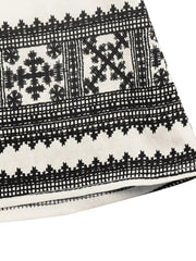 Geometric print midi dress with black embroidery on white fabric.