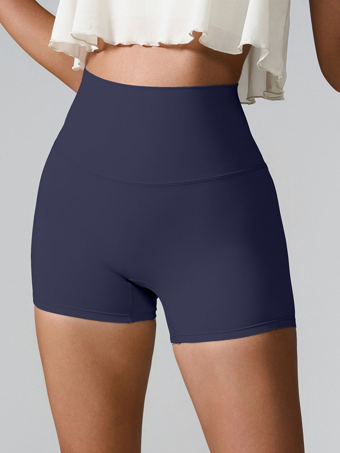 Navy high-waisted active shorts with sculpted pocket detail and seamless design.