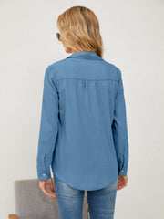 Light wash denim utility shirt with button cuffs and a curved hem.