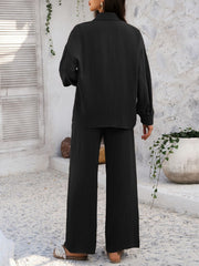 Black textured resort shirt and wide leg pants set with buttoned front and collared neckline.