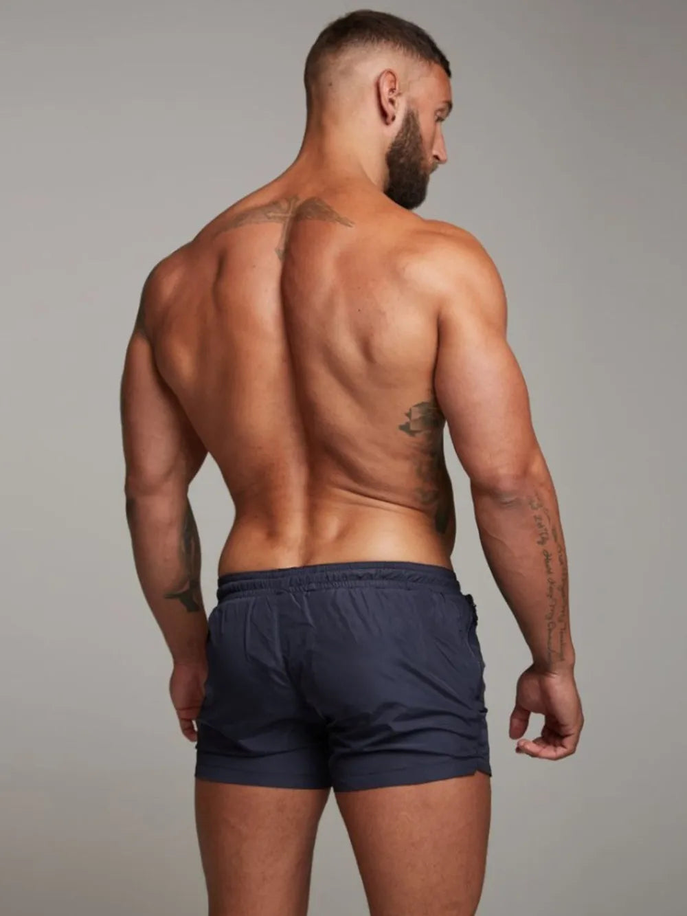 Navy swim shorts with zip pocket detail and elastic waistband.