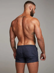 Navy swim shorts with zip pocket detail and elastic waistband.