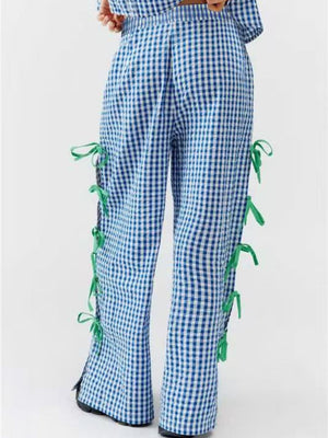 Blue gingham wide-leg trousers with green bow details down the sides.