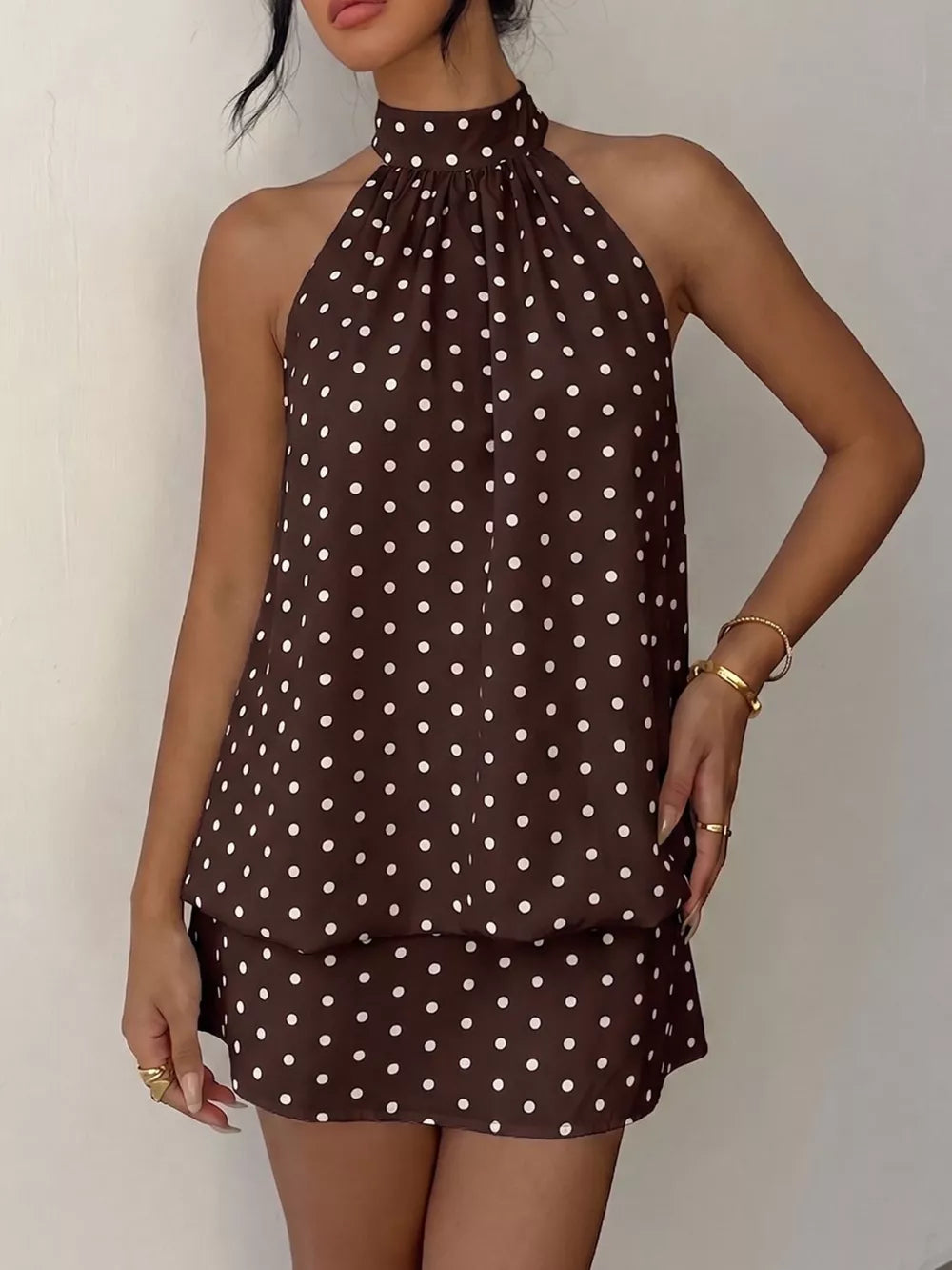 Chic polka dot halter mini dress in coffee brown with white dots, featuring a gathered neckline and sleeveless design.