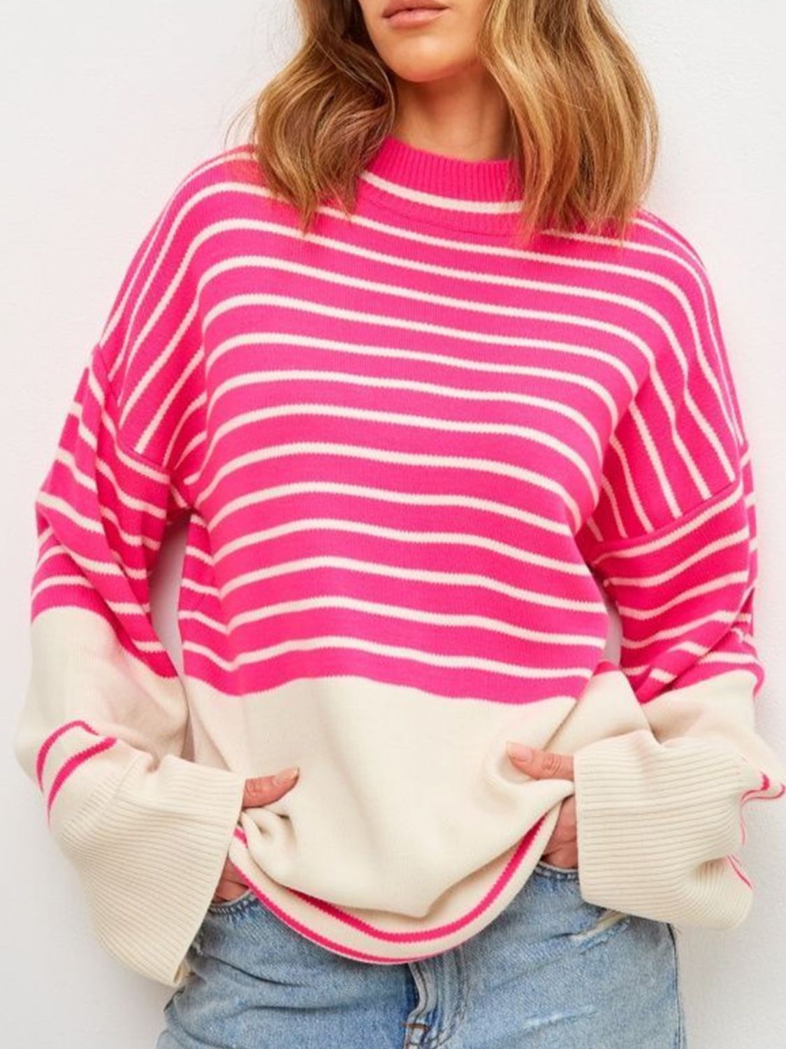 Colorblock stripe knit sweater with bell sleeves in pink and cream.