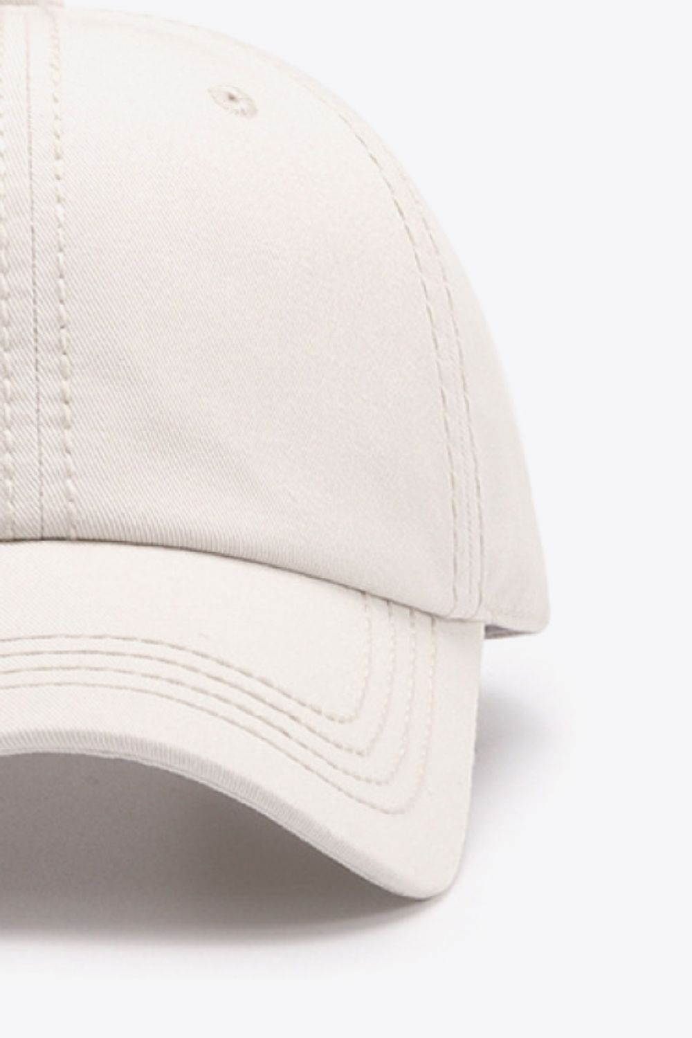 Beige canvas baseball cap with stitched detailing and curved brim.