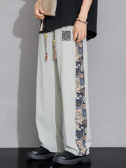Men's light gray sweatpants with printed side stripe and drawstring.
