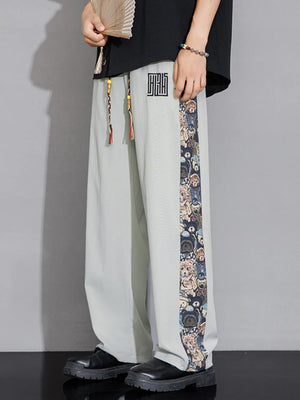 Men's light gray sweatpants with printed side stripe and drawstring.