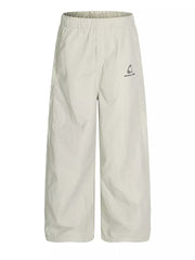 Men's light gray wide-leg sweatpants with crinkled texture and embroidered logo detail.