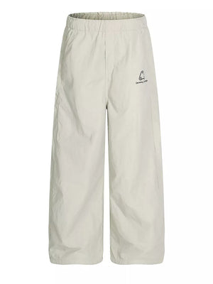 Men's light gray wide-leg sweatpants with crinkled texture and embroidered logo detail.