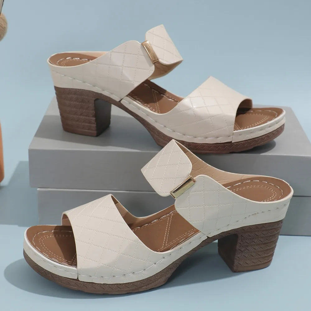 Ivory quilted leather platform mules with block heel and gold buckle detail.