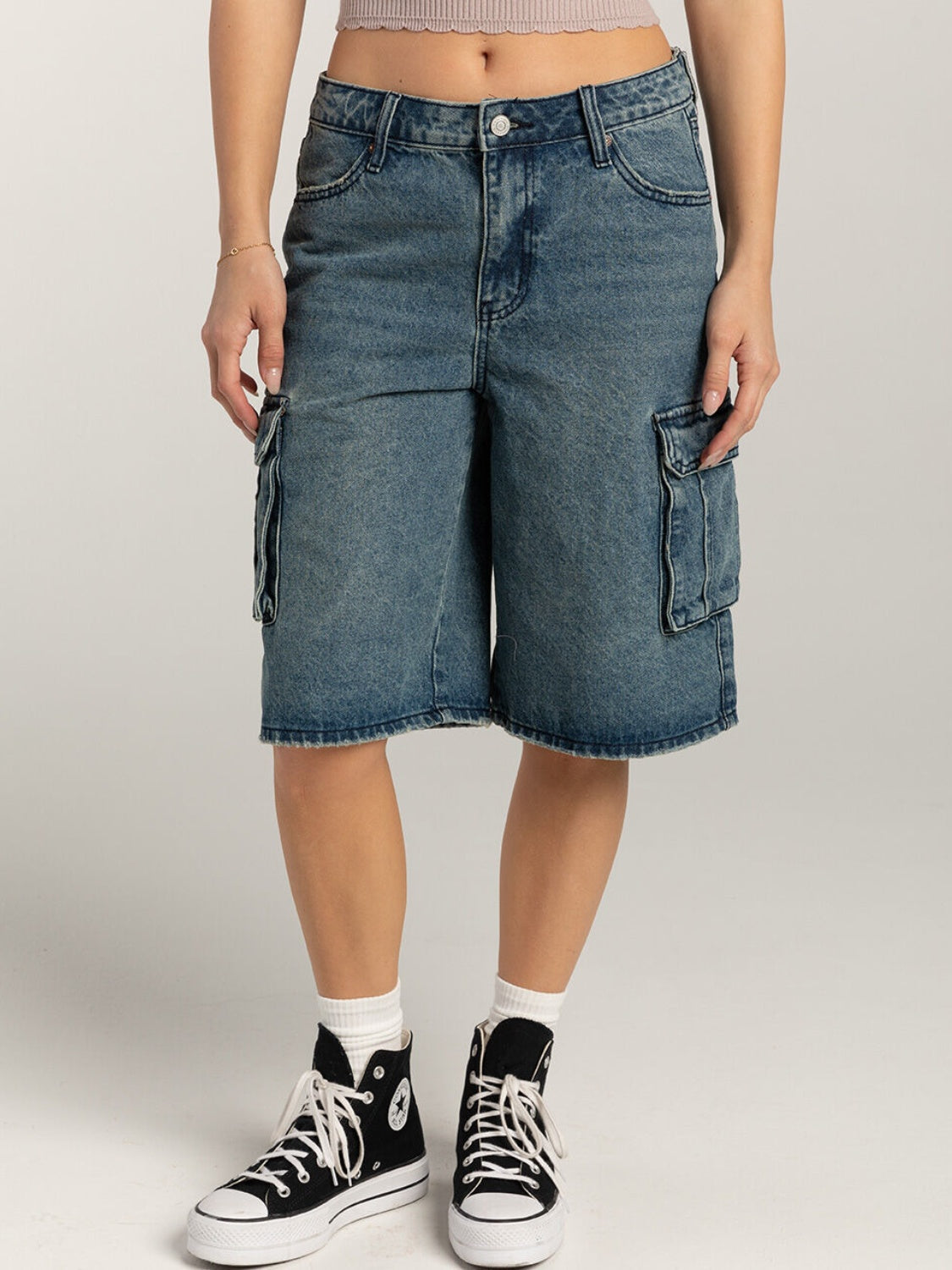 Light blue denim cargo bermuda shorts with button closure and flap pockets.