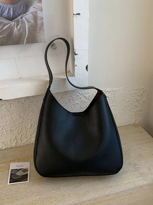 Black pu leather shoulder bag with a sleek, minimalist design and curved strap.