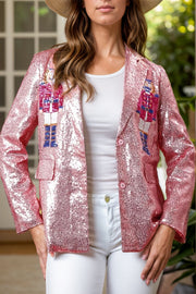 Dusty pink sequin blazer with nutcracker appliqué, buttoned front, and notched lapels.
