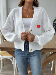 White knit cardigan with red heart appliqué and balloon sleeves.
