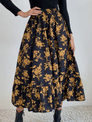 Tiered midi skirt in black with a yellow floral print and ruffled hem.