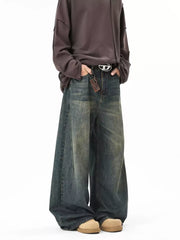 Vintage wash oversized baggy blue cotton jeans with a belted waist and distressed details.