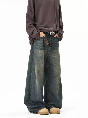 Vintage wash oversized baggy blue cotton jeans with a belted waist and distressed details.