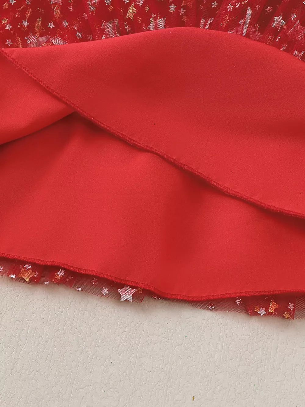 Red baby dress with star-print tulle hem and pom-pom details