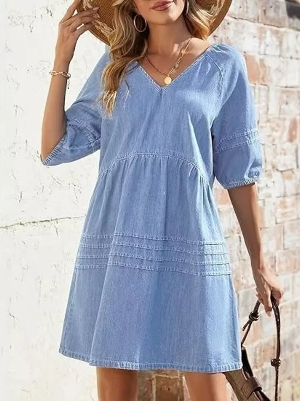 Light blue denim mini dress with V-neck, puff sleeves, and tiered skirt detail.