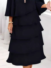 Black tiered ruffled dress with 3/4 sleeves and a bracelet.