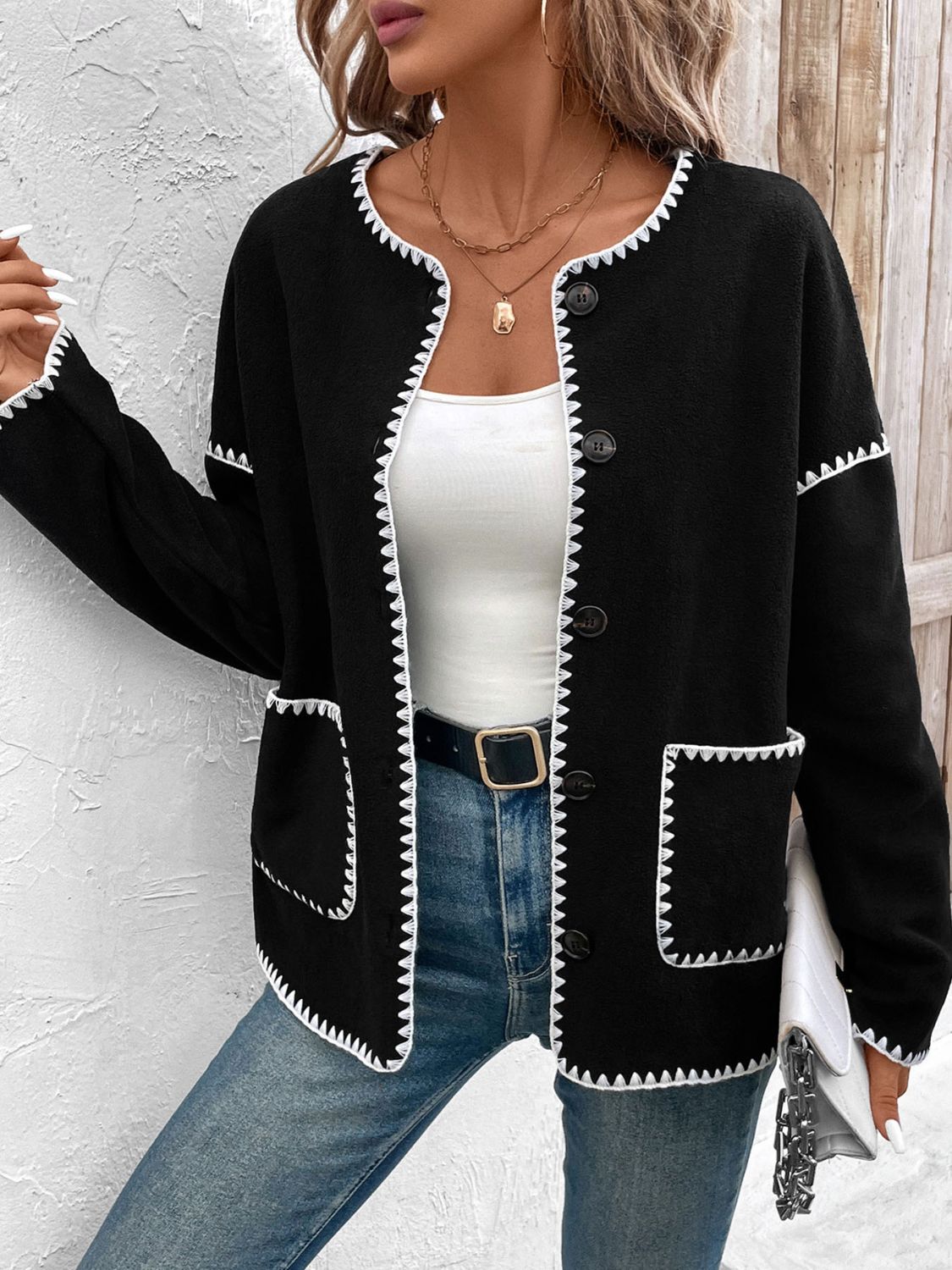 Black knit jacket with white scalloped trim and button front.
