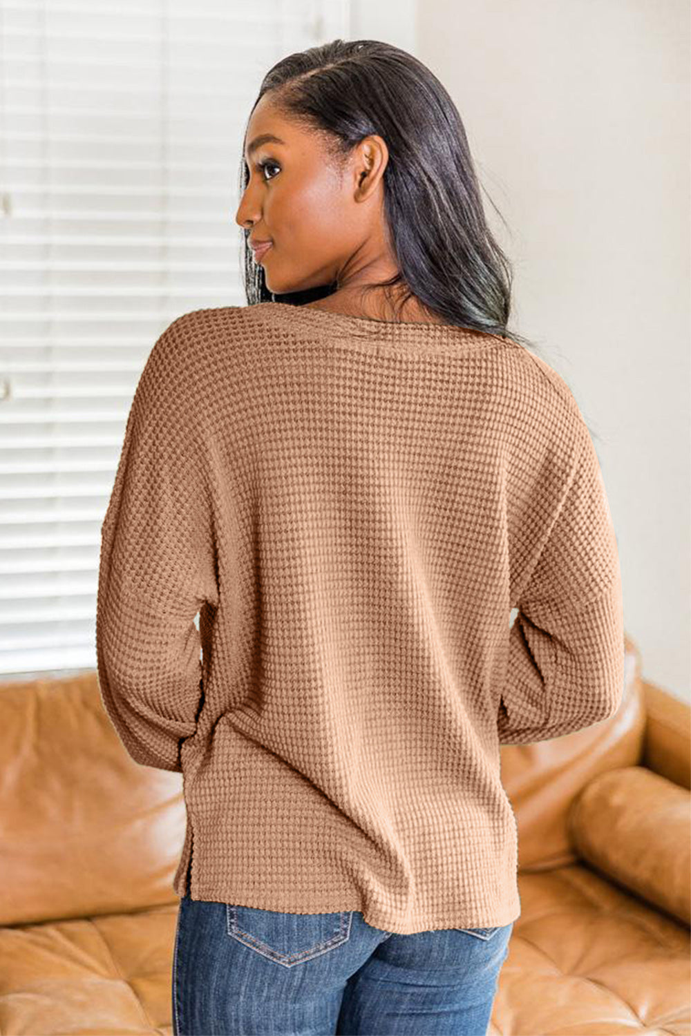 Camel waffle knit henley pullover with button detail and side slits.
