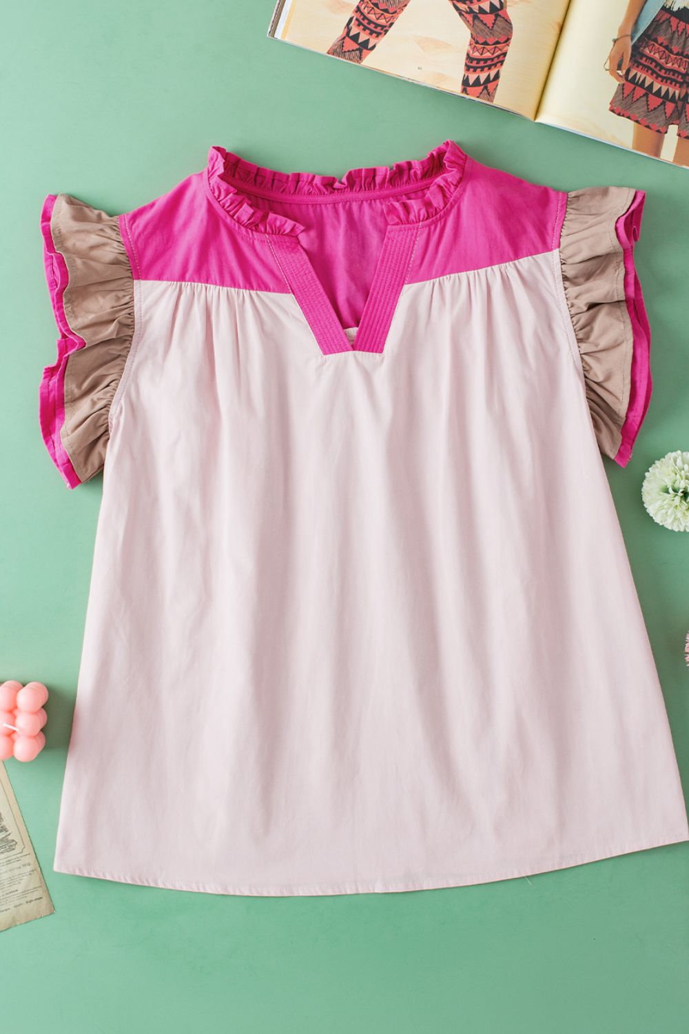 Blush pink and light blue colorblock blouse with ruffle yoke and flutter sleeves.