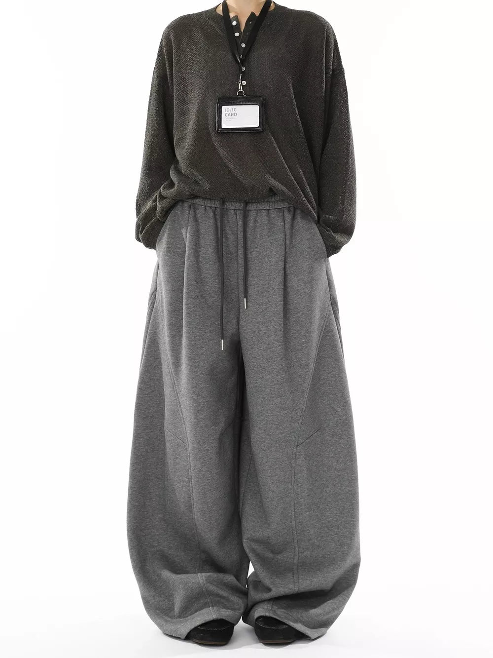 Men's gray wide-leg drawstring sweatpants with a relaxed fit and visible stitching details.