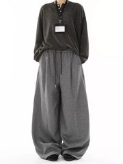 Men's gray wide-leg drawstring sweatpants with a relaxed fit and visible stitching details.