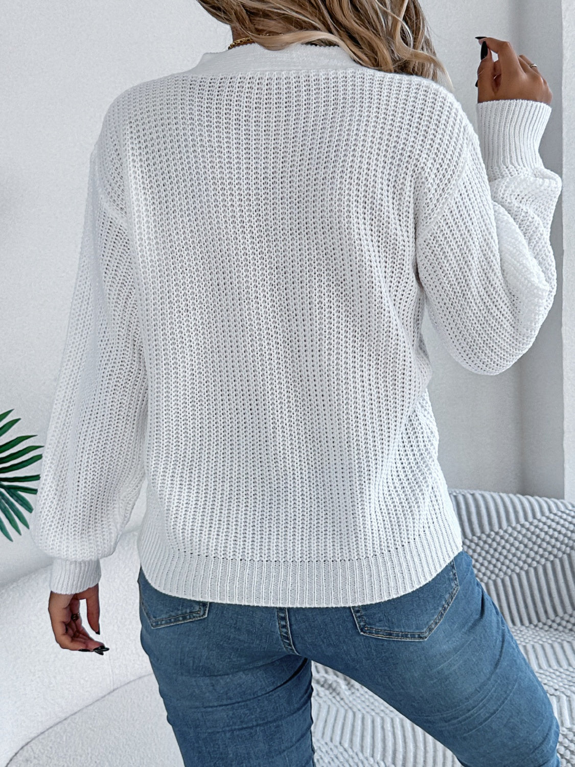 White cable knit sweater with crew neck and long sleeves, casual acrylic knit.