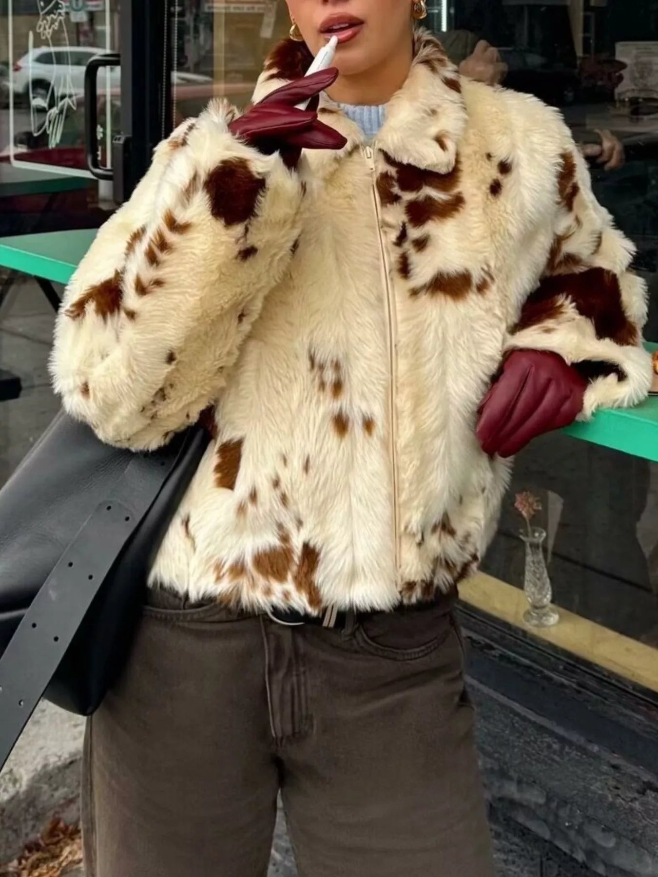 Cropped faux fur zip up jacket in beige with brown spots, featuring a collar and zip closure.