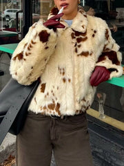 Cropped faux fur zip up jacket in beige with brown spots, featuring a collar and zip closure.