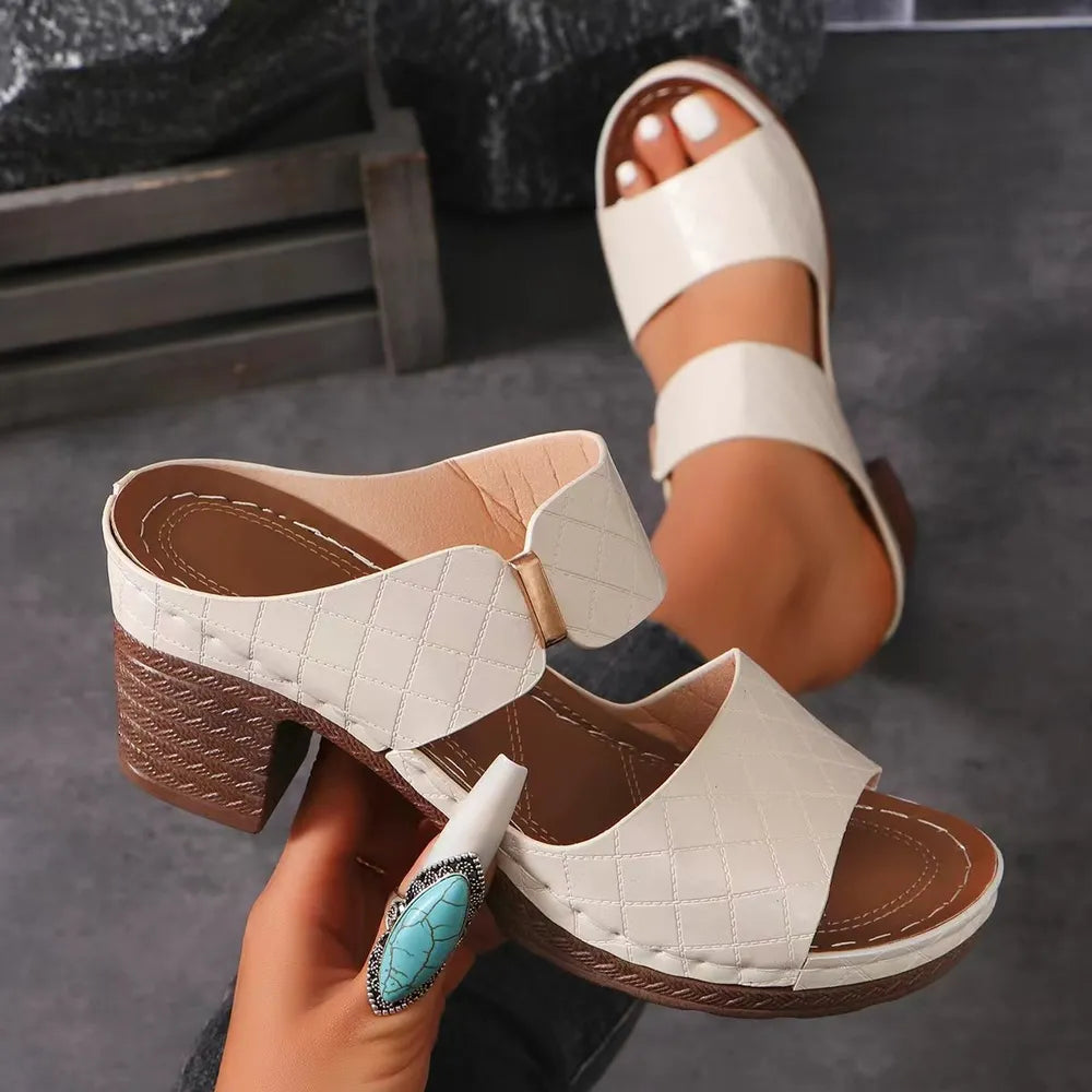 Ivory quilted leather platform mules with block heel and open toe.