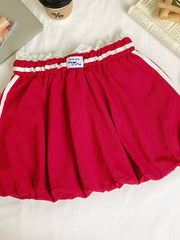 Red mini skirt with lace trim, gathered waist, and white side stripes.