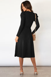 Black cable knit midi dress with long sleeves and a flared skirt.