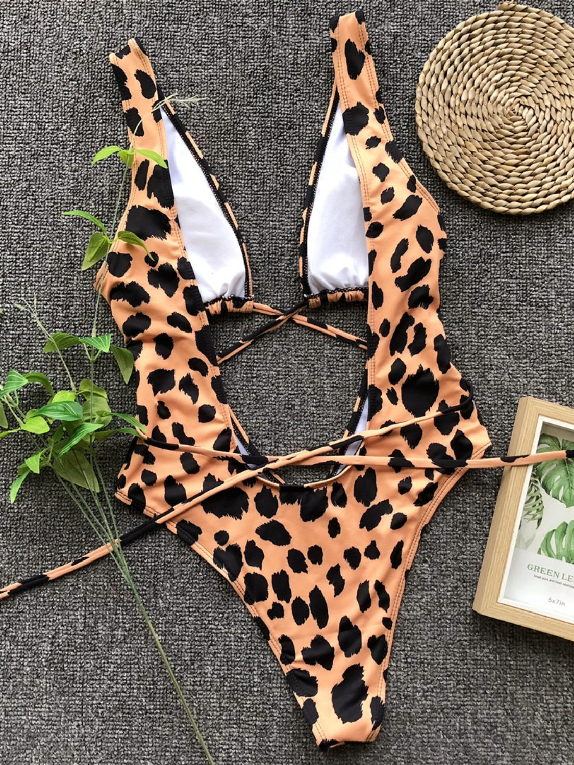One-piece swimsuit with leopard print, plunging neckline, and crisscross back straps.