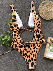One-piece swimsuit with leopard print, plunging neckline, and crisscross back straps.