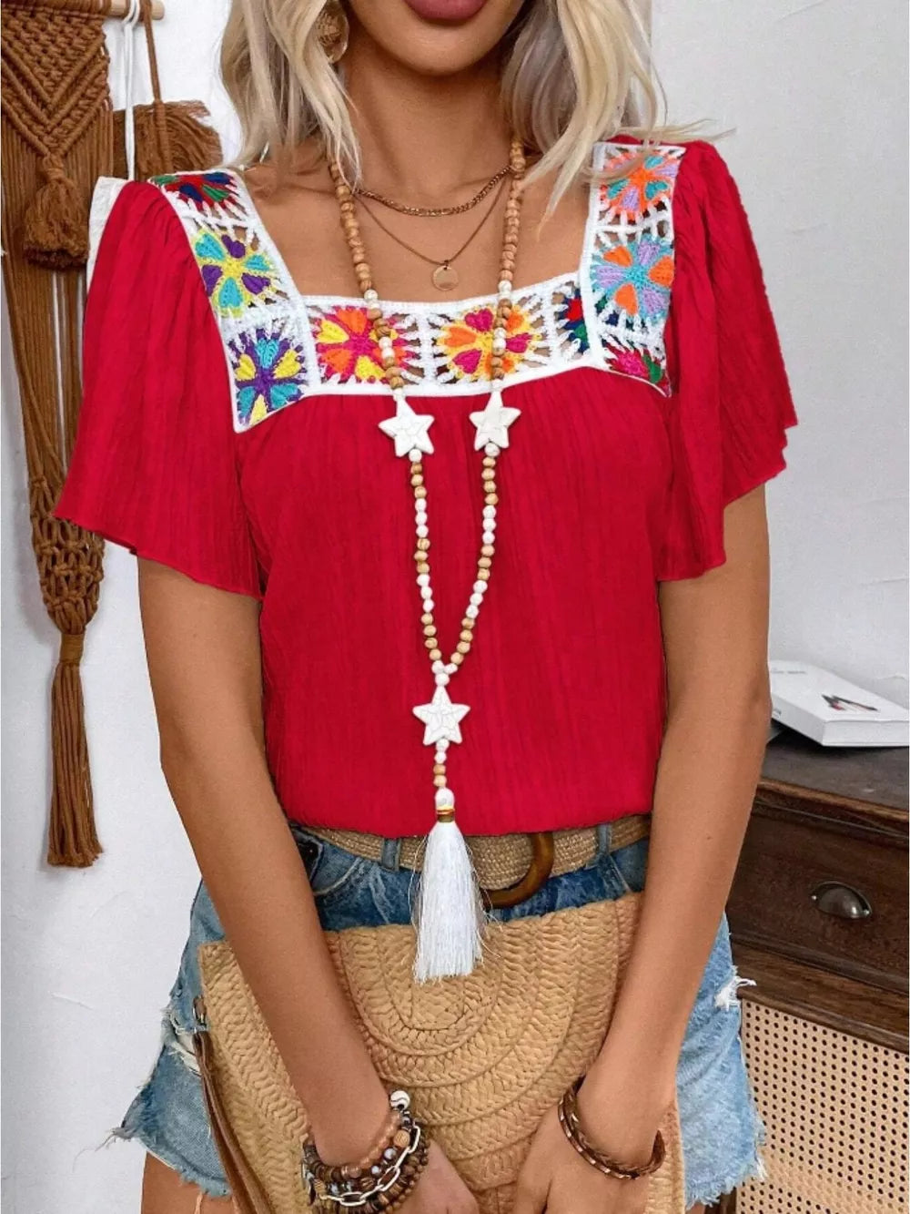 Red embroidered square neck blouse with flutter sleeves and colorful crochet detail.