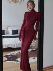 Burgundy turtleneck maxi dress with long sleeves and a ruched tie detail on the side.