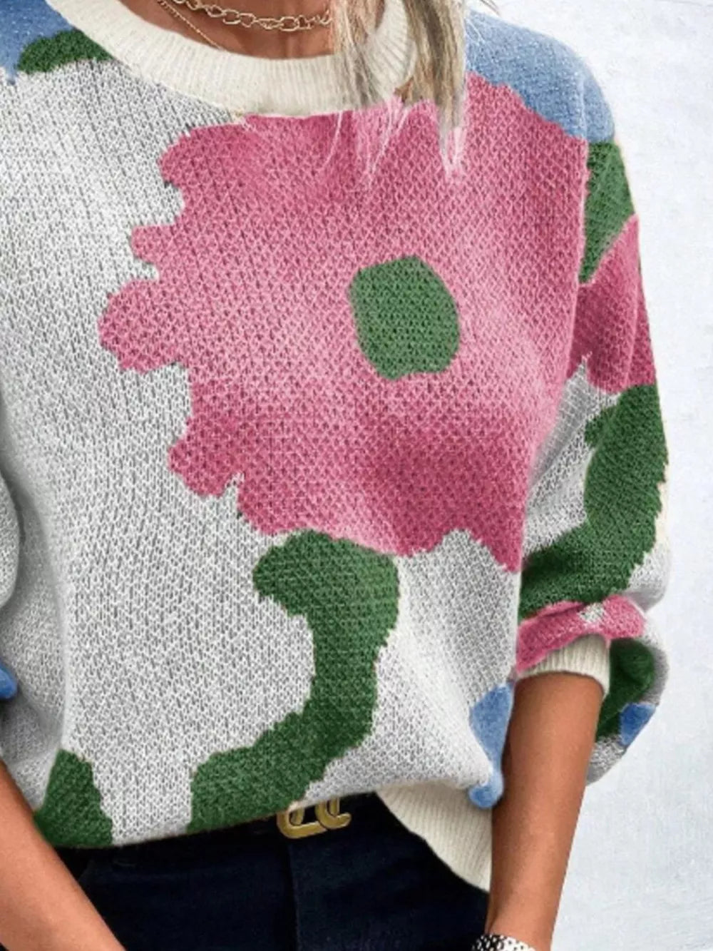 Abstract floral knit sweater with round neck in pink, green, blue, and black.