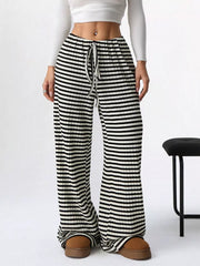 Striped ribbed wide-leg pants with drawstring waist in black and white.