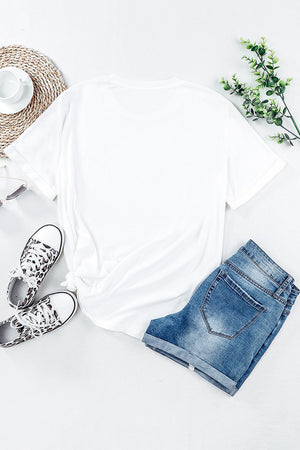 White t-shirt with rolled sleeves and a knotted hem, styled with denim shorts and leopard print sneakers.
