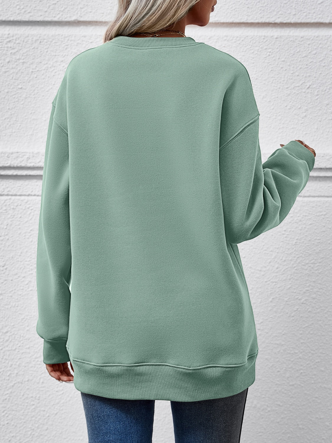 Sage green crewneck sweatshirt with ribbed cuffs and hem, relaxed fit.