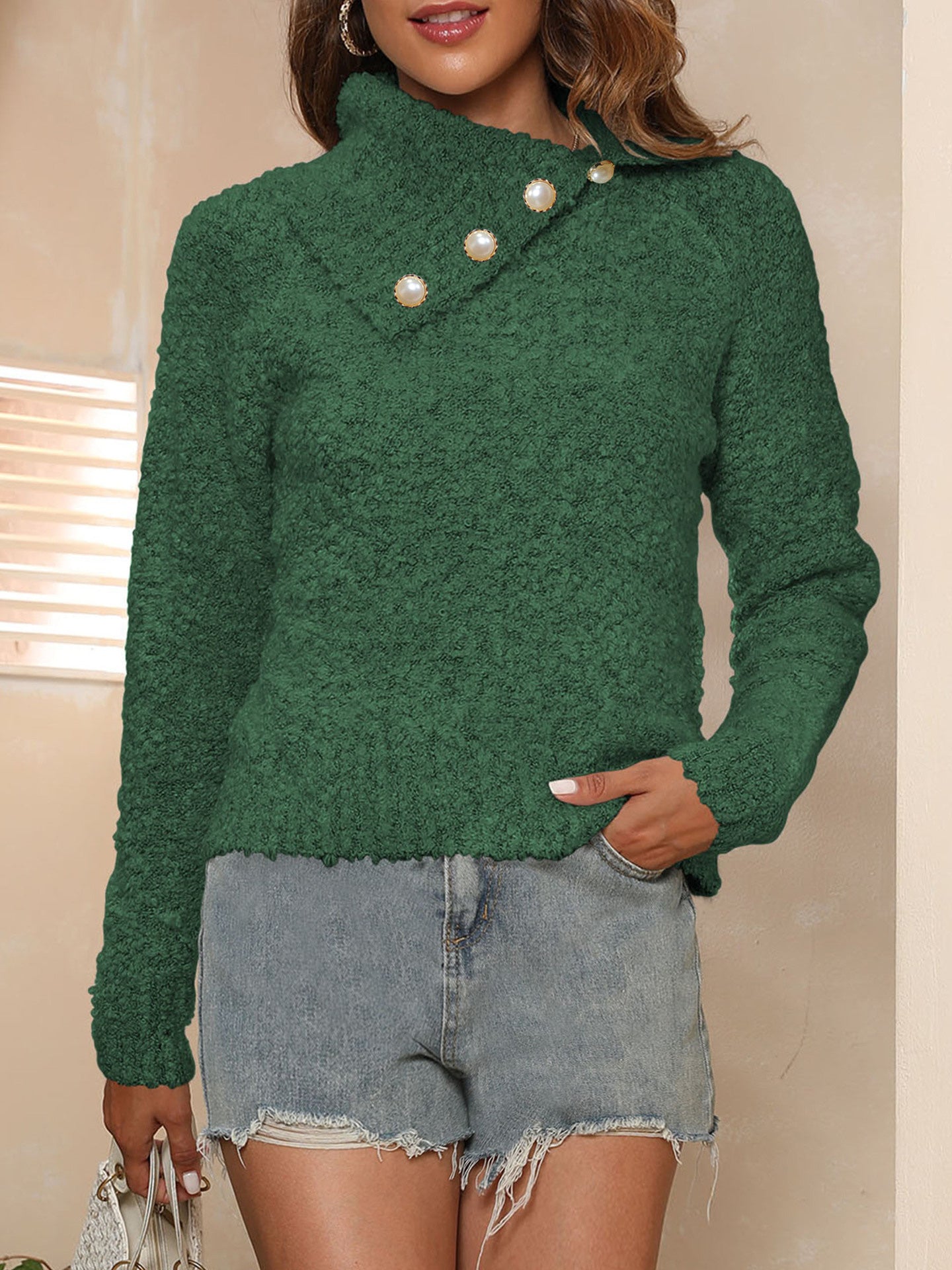 Dark green textured knit sweater with pearl buttons and asymmetric neckline.