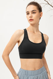 Black mesh-inset performance sports bra with scoop neck and racerback straps.