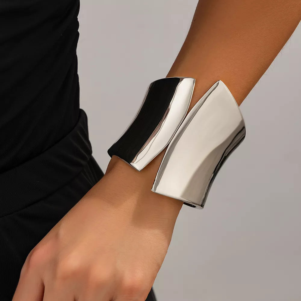 Sculptural silver-toned cuff bracelet with a modern, open design.