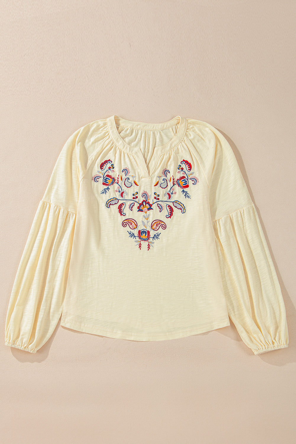 Pastel yellow blouse with embroidered floral detail and poet sleeves.