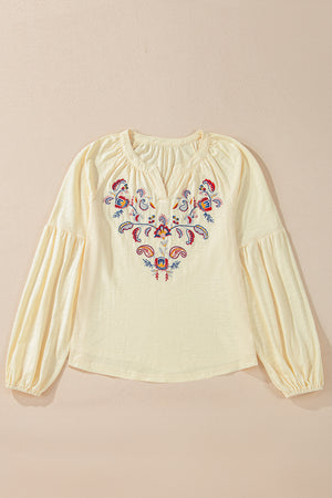 Pastel yellow blouse with embroidered floral detail and poet sleeves.