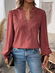 Rust embroidered yoke blouse with puff sleeves and textured fabric.